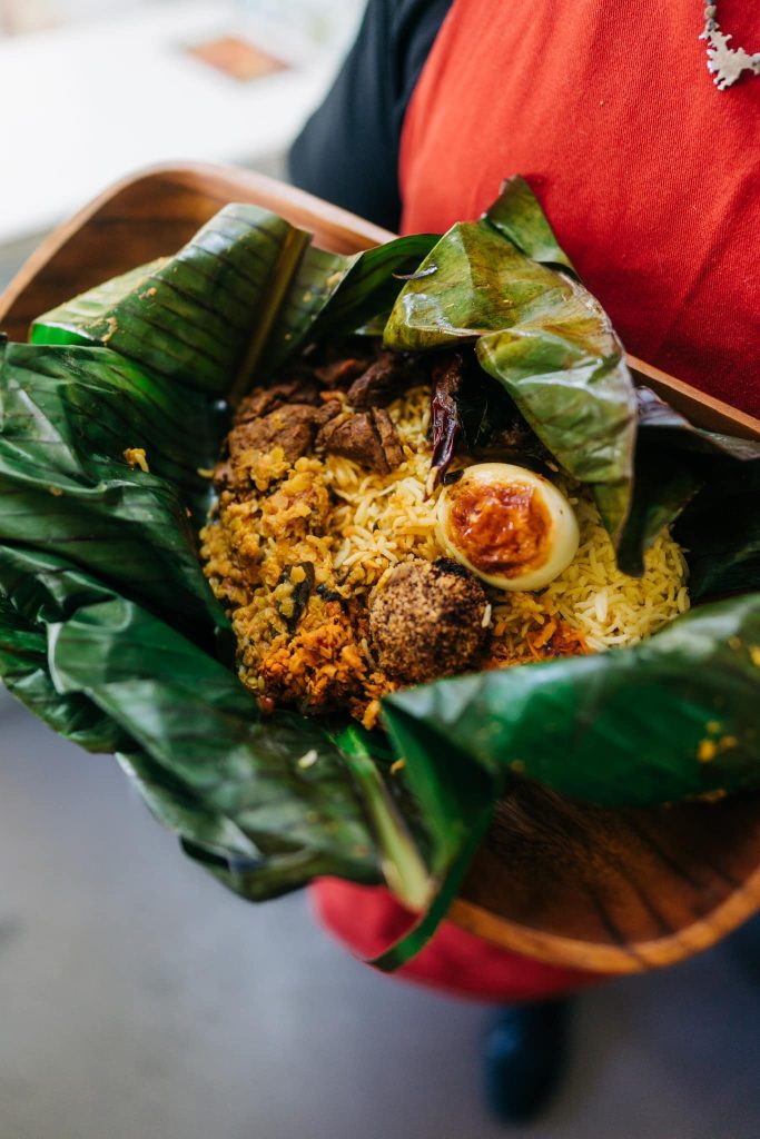 Chef holding Lamprais in banana leaf